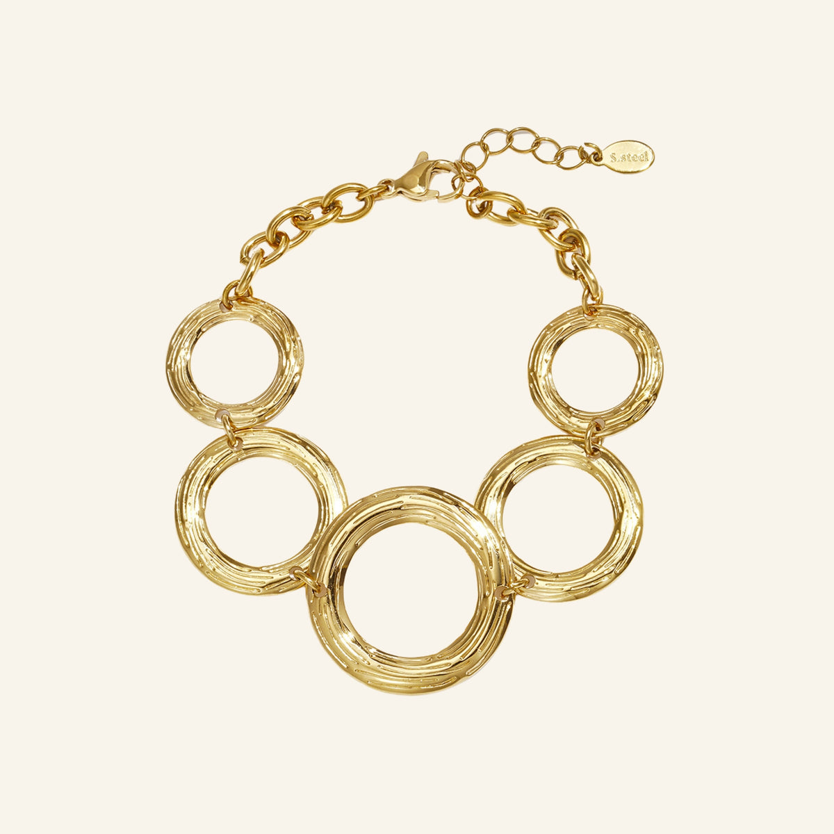 Cirkel schakelarmband goud – vrijstaand op beige