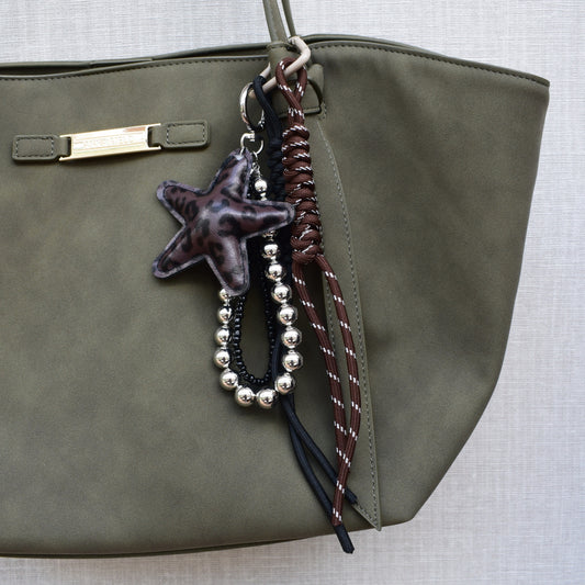 Ster bag charm met kralen bruin aan een tas