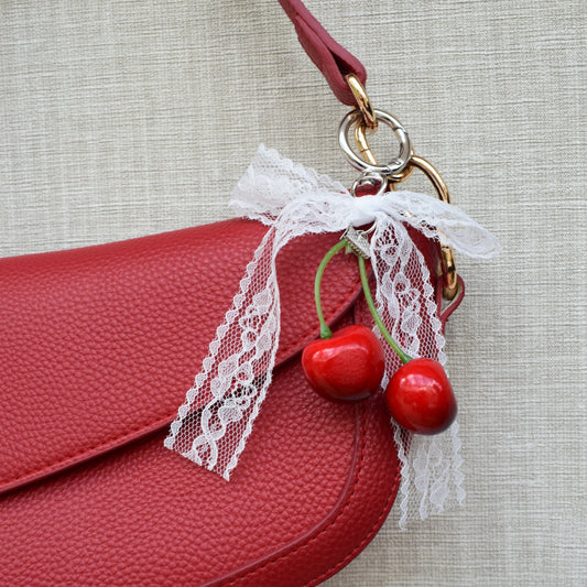 Kersen met kanten strik bag charm aan rode tas