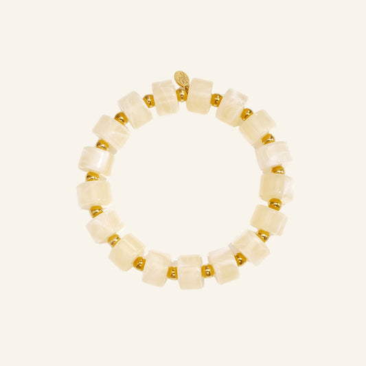 Crème kralenarmband met goud – vrijstaand op beige