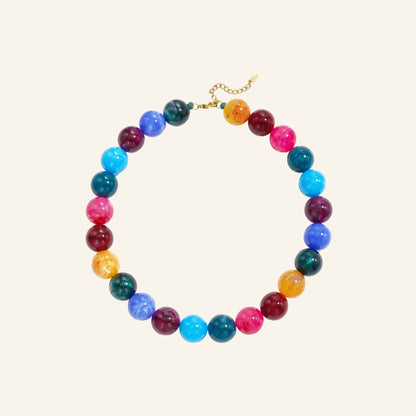 Chunky ronde kralenketting – gemengde kleuren vrijstaand op beige