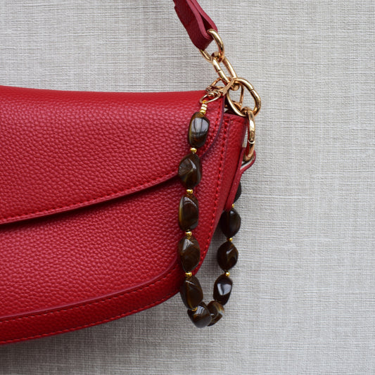 Kralen bag charm bruin aan rode tas