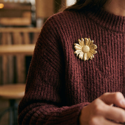 Bloem broche goud op een bordeaux trui