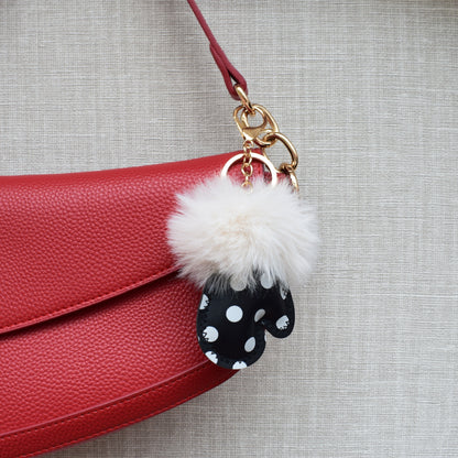 Handschoen polka dots fluffy bag charm aan rode tas