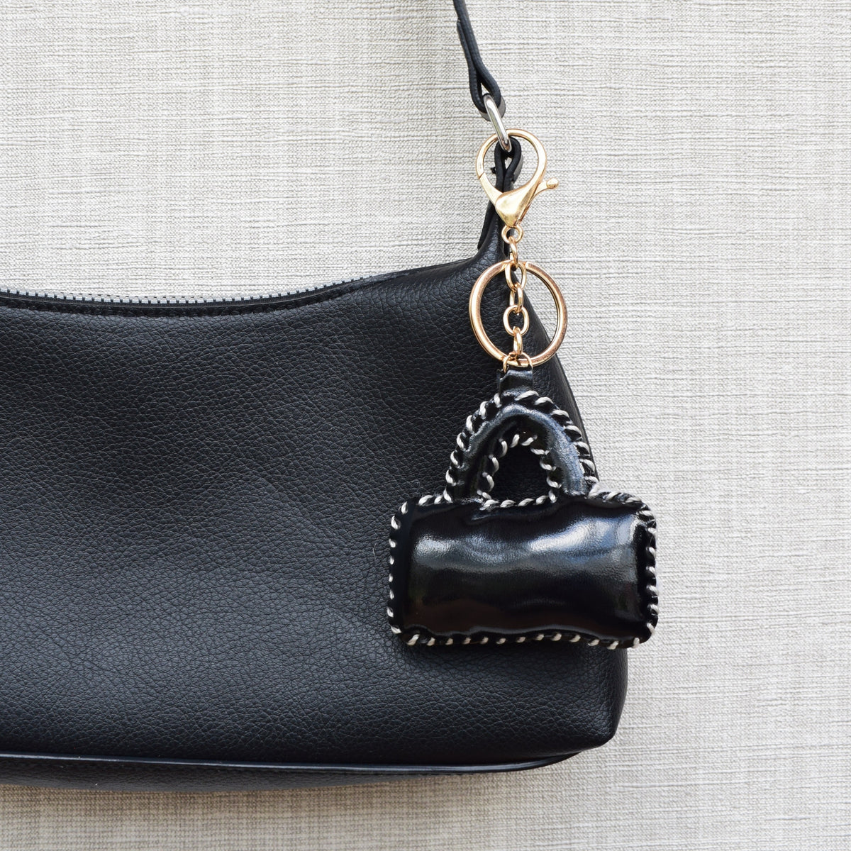 Mini tasje bag charm zwart aan zwarte tas