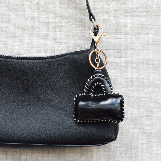 Mini tasje bag charm zwart aan zwarte tas