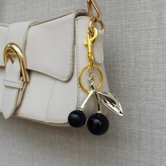 Kersen bag charm zwart aan witte tas
