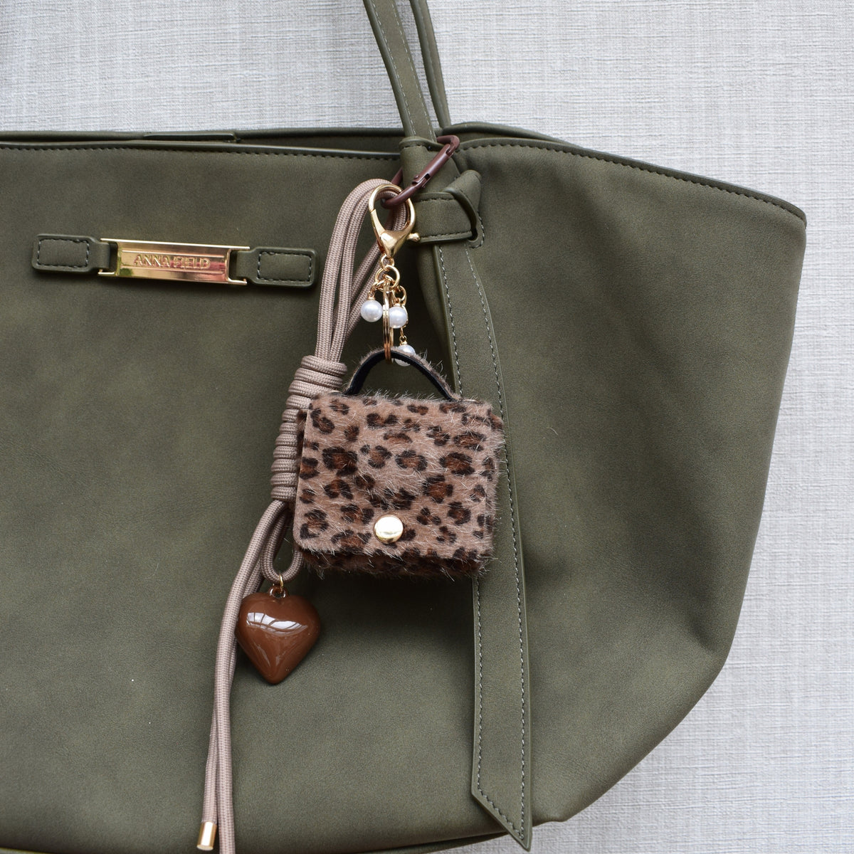 Mini tasje bag charm panterprint aan een groene tas