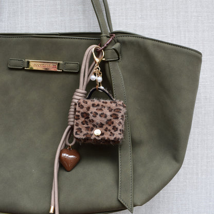 Mini tasje bag charm panterprint aan een groene tas