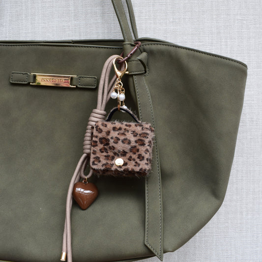Mini tasje bag charm panterprint aan een groene tas