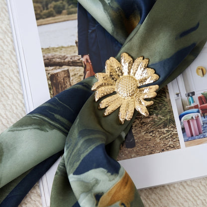 Bloem broche goud als sjaalsluiting op een groene sjaal