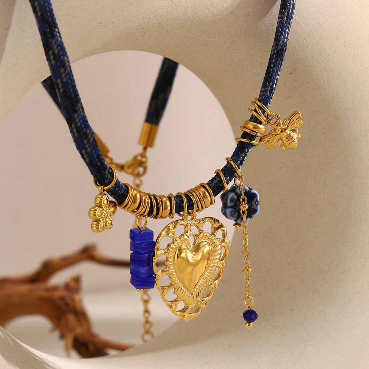 Hart bedelketting blauw – sfeerfoto met houten decor