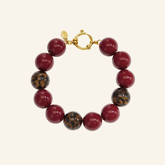 Kralenarmband met luipaard accent – bordeaux vrijstaand op beige