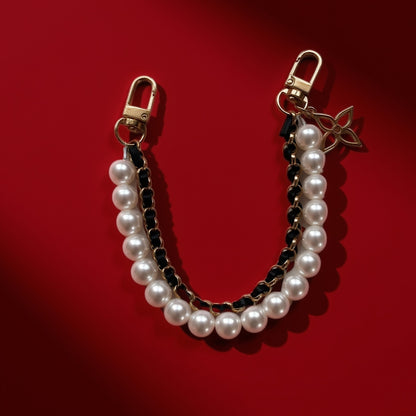 Parels bag charm zwart op rode achtergrond