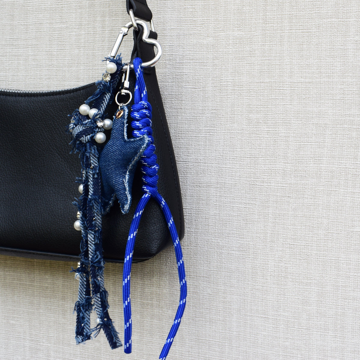 Ster van stof bag charm blauw aan zwarte tas