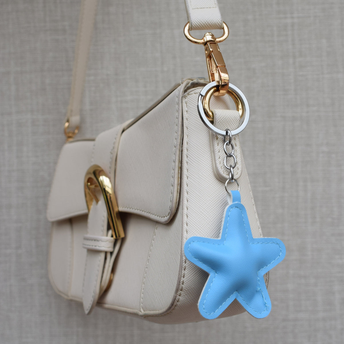 Ster van stof bag charm lichtblauw aan tas, close-up