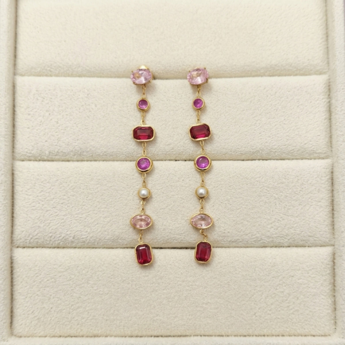 Pink stone gold earrings in a jewelry box