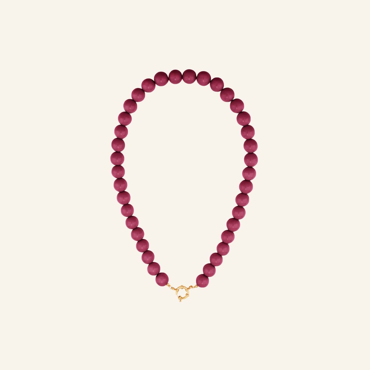 Glanzende kralenketting – fuchsia vrijstaand op beige