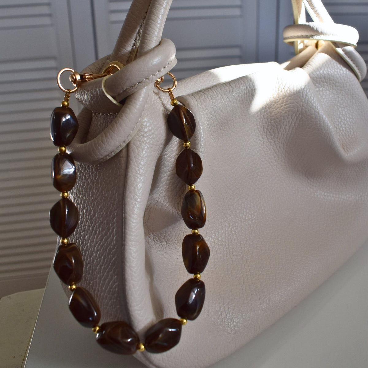 Beaded bag charm brown on a white bag