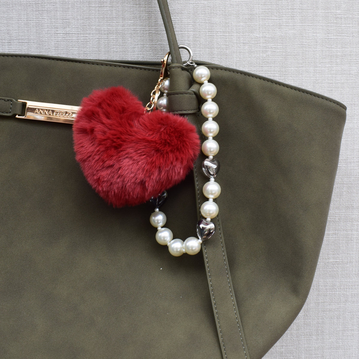 Fluffy hart bag charm rood aan groene tas
