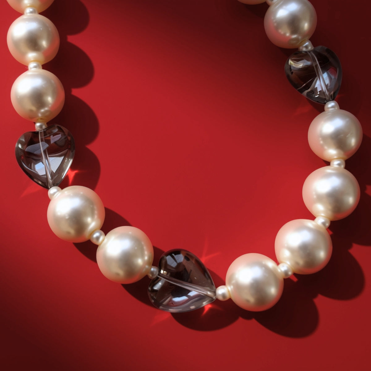 Hearts and pearls bag charm on red background
