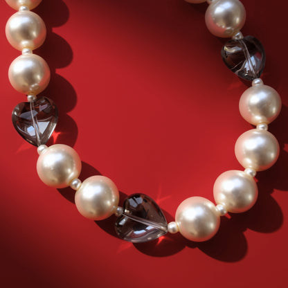 Hearts and pearls bag charm on red background