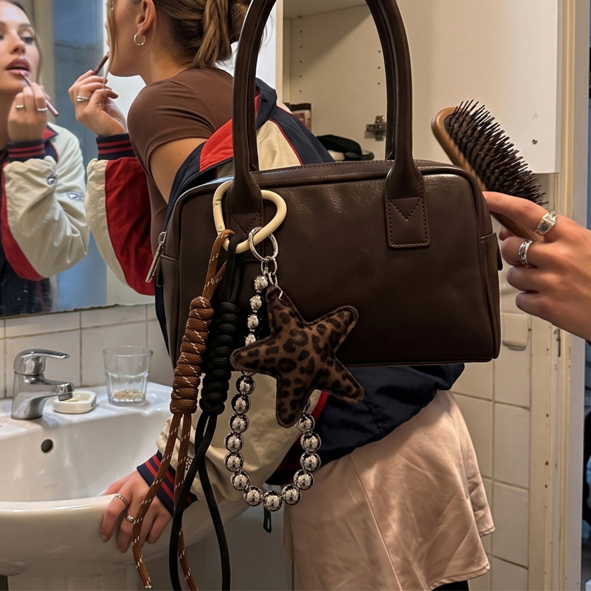 Ster bag charm met kralen bruin aan een tas, sfeerfoto