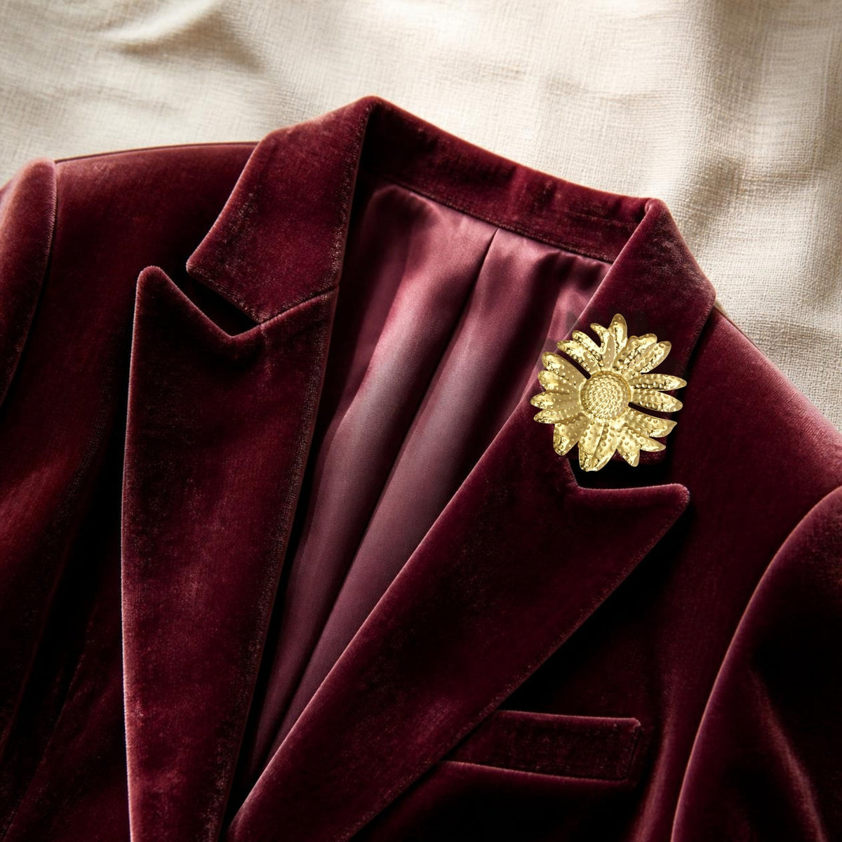 Bloem broche goud op een bordeaux fluwelen blazer
