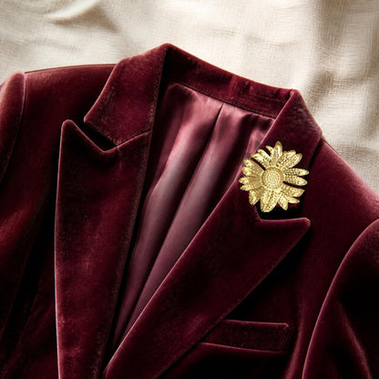 Bloem broche goud op een bordeaux fluwelen blazer