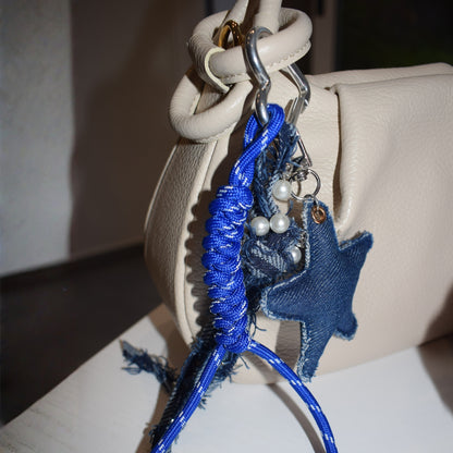 Ster van stof bag charm blauw aan tas