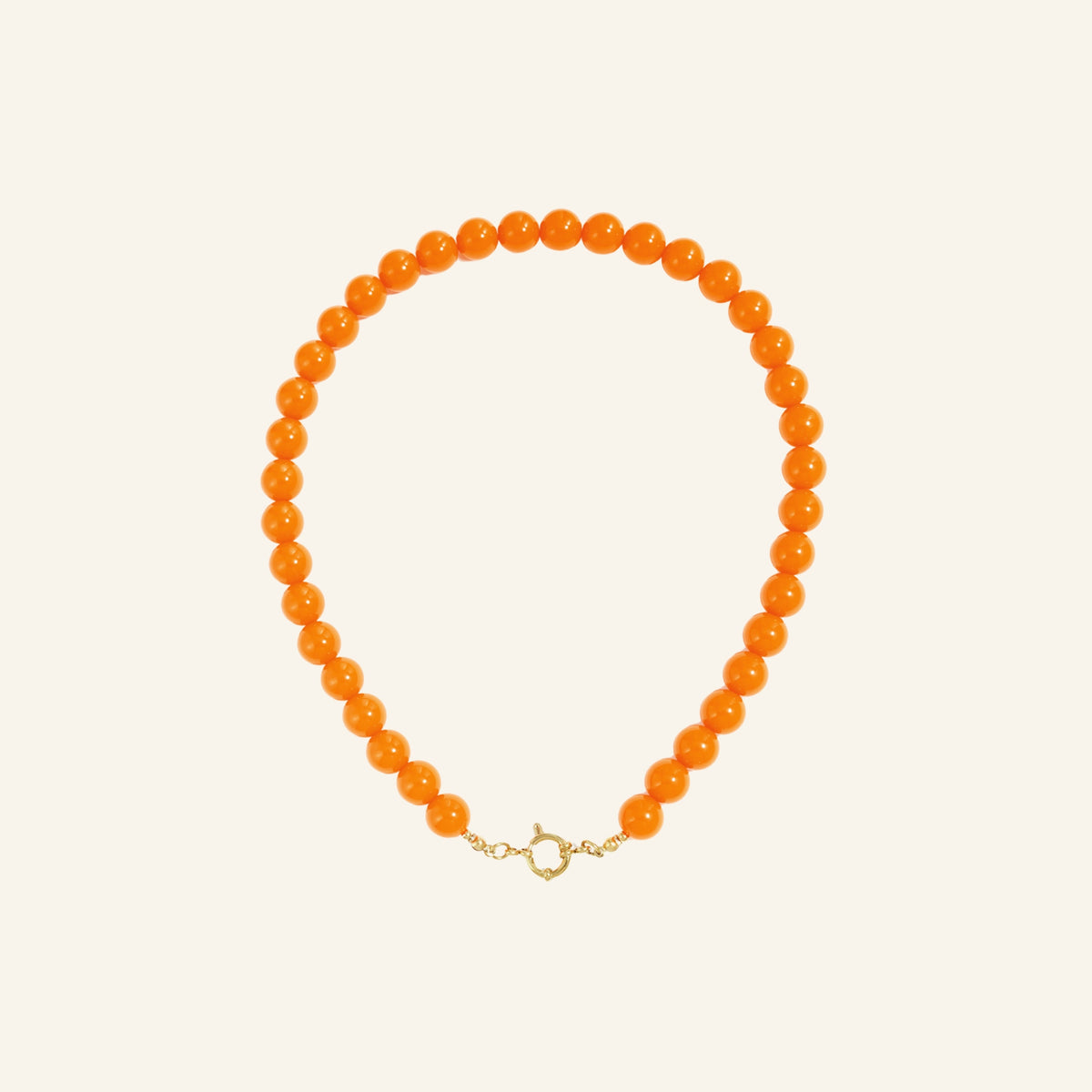 Glanzende kralenketting – oranjerood vrijstaand op beige