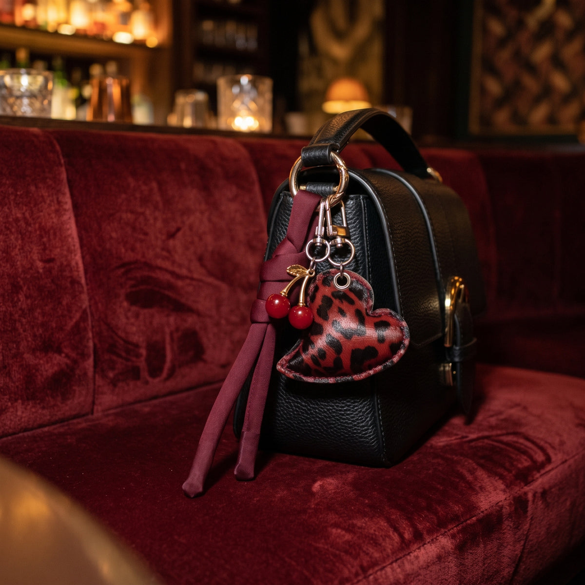 Hart en kers bag charm rood aan een zwarte tas, sfeerfoto