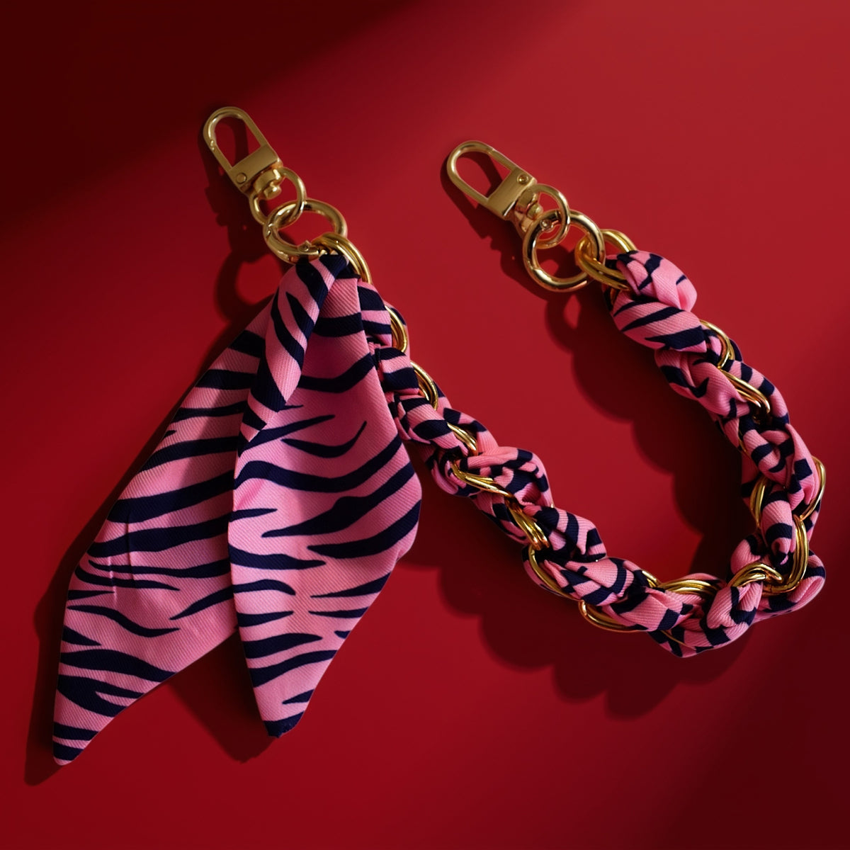 Sjaal bag charm roze op rode achtergrond