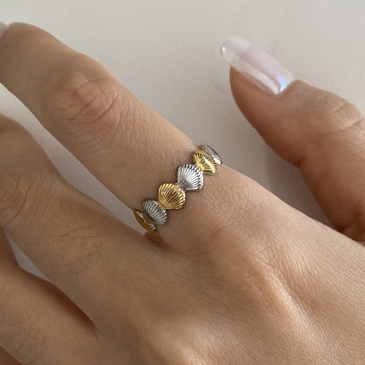 Seashell ring gold silver – worn, close-up of the hand