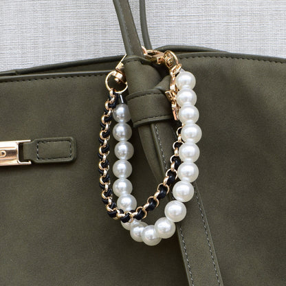 Parels bag charm zwart aan groene tas, close-up