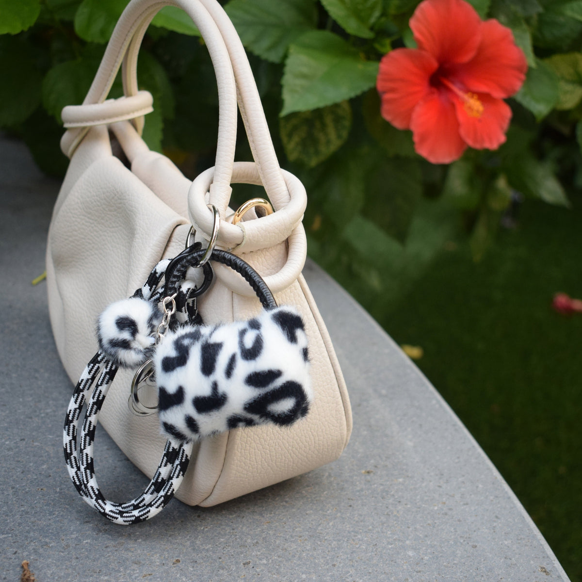 Mini tasje fluffy bag charm zwart aan beige tas