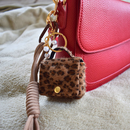 Mini tasje bag charm panterprint bij een rode tas