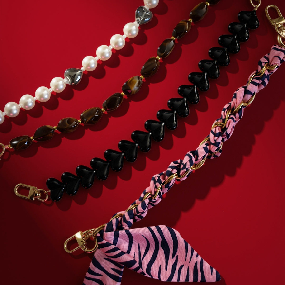 Sjaal bag charm roze met kettingen op rood
