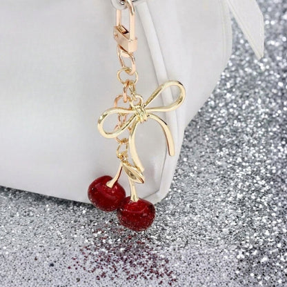 Kersen met strik bag charm aan witte tas