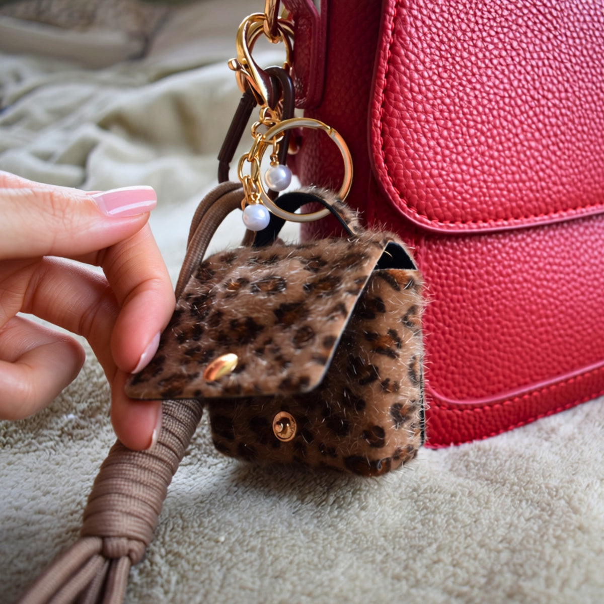 Mini tasje bag charm panterprint aan een rode tas, detail
