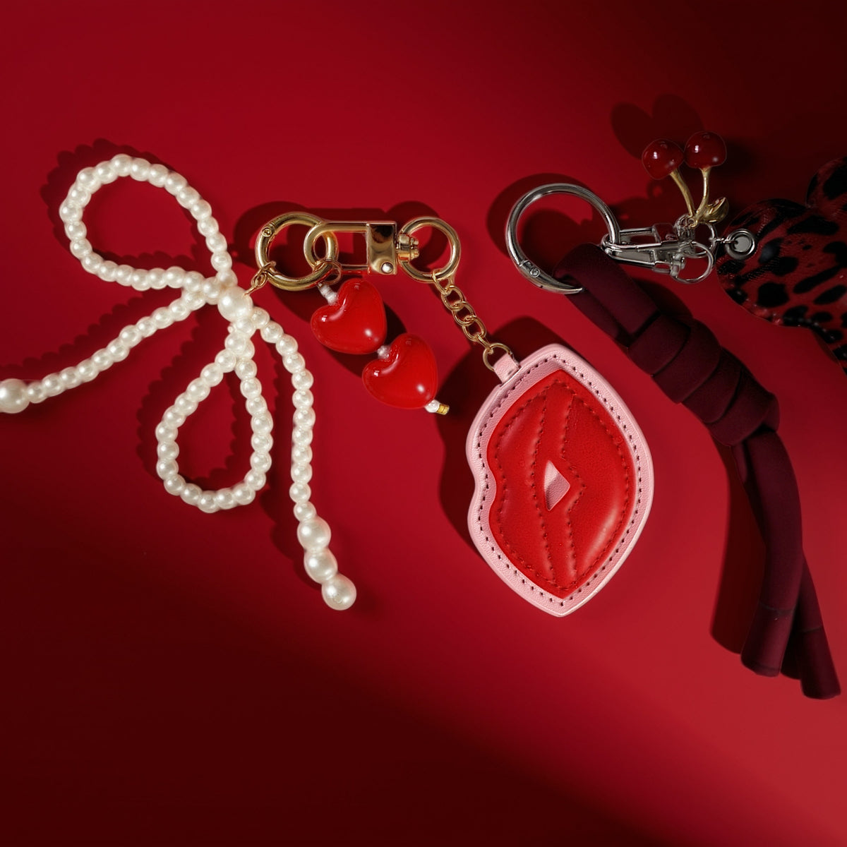 Kus met parels bag charm met andere bag charms op rood