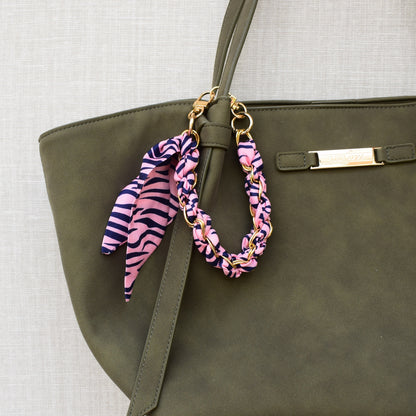 Sjaal bag charm roze aan groene tas, close-up