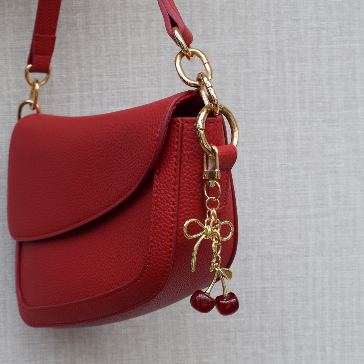 Kersen met strik bag charm aan rode tas