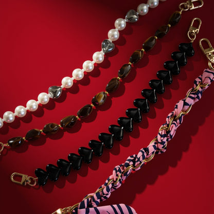 Bag charms on red background, including hearts and pearls