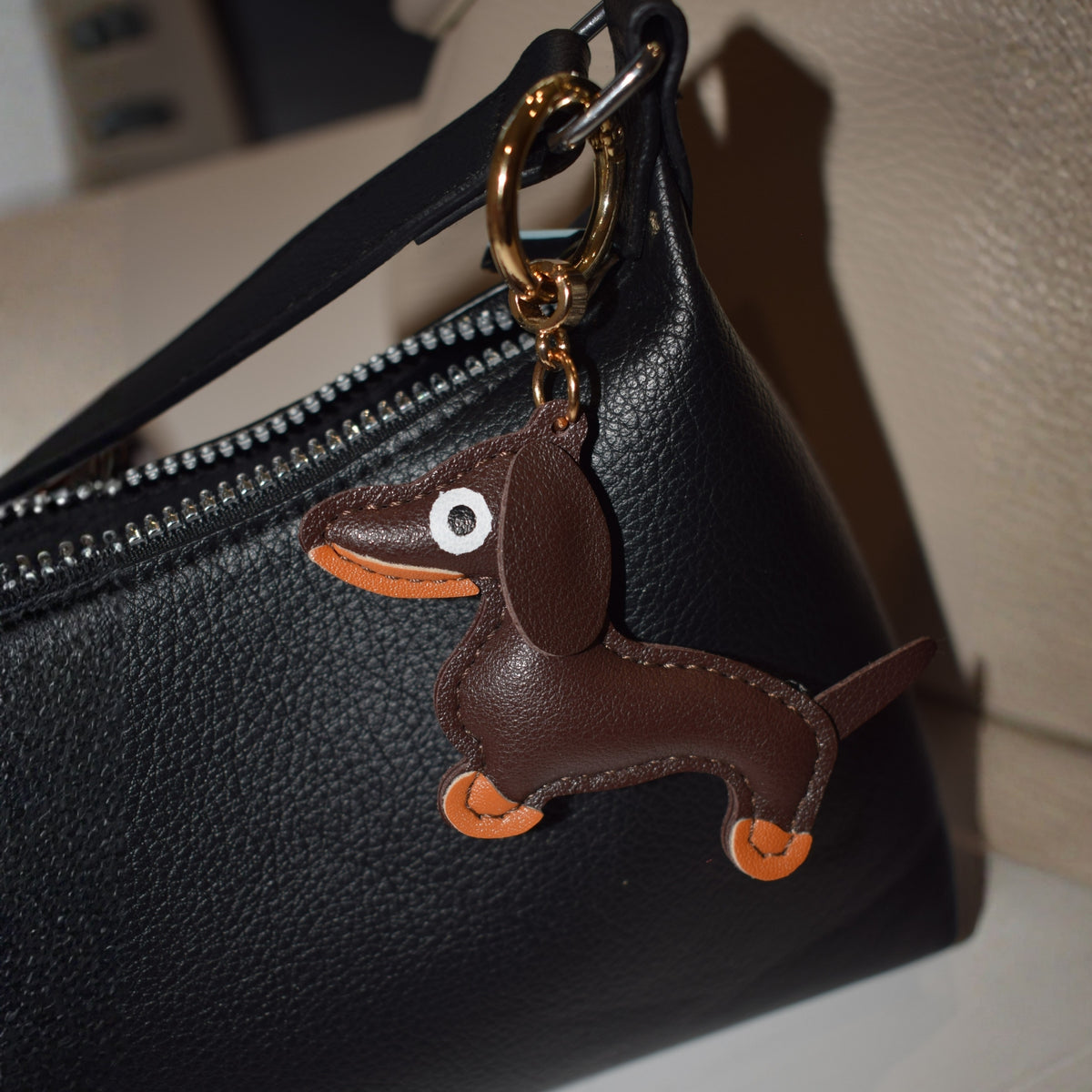 Hond van stof bag charm aan zwarte tas