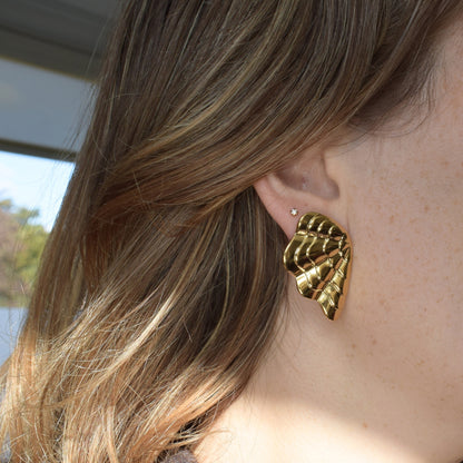 Gold shell earrings – close-up on glitter