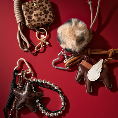 Bag charms on red background, including brown Pegasus