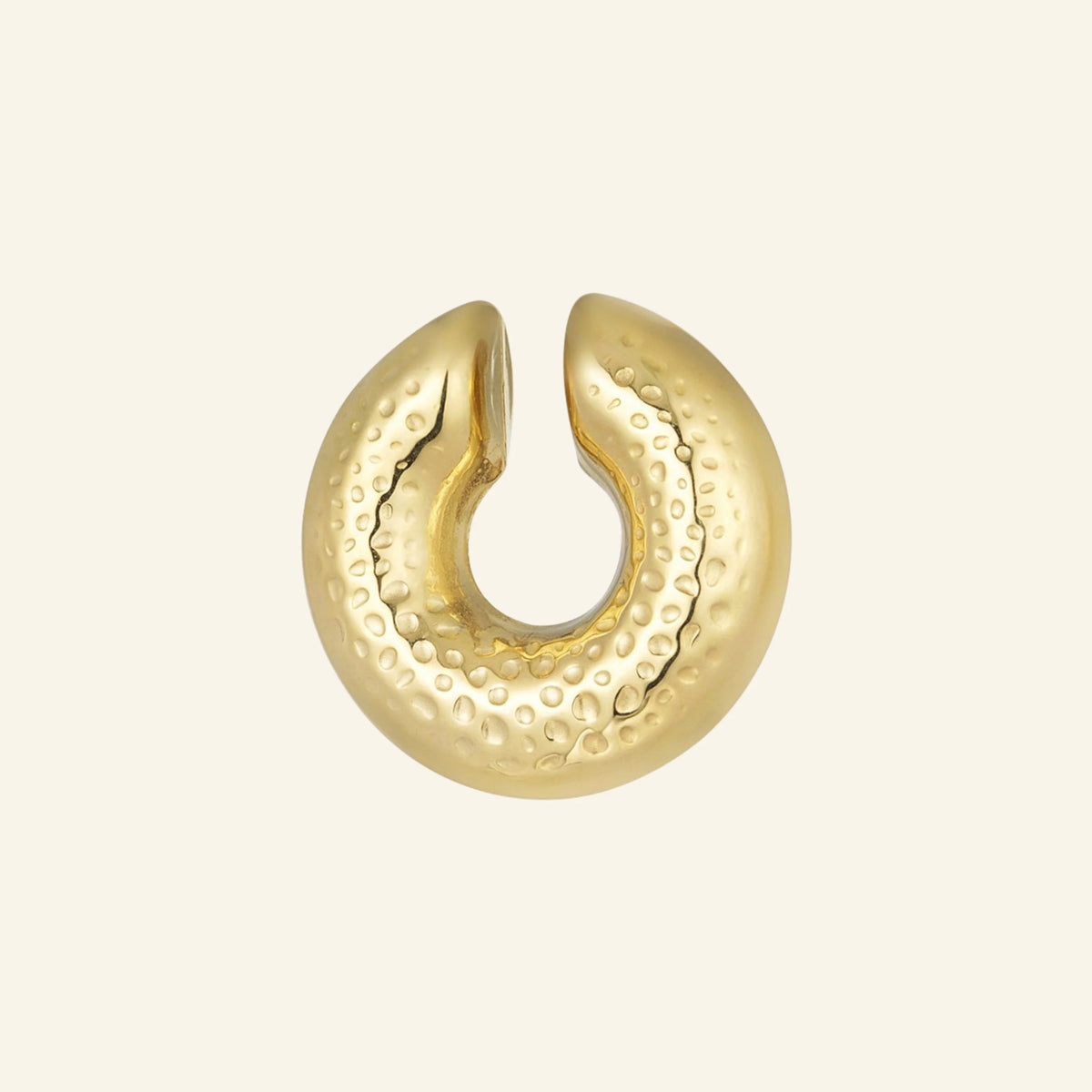 Gold hammered ear cuff – on beige background