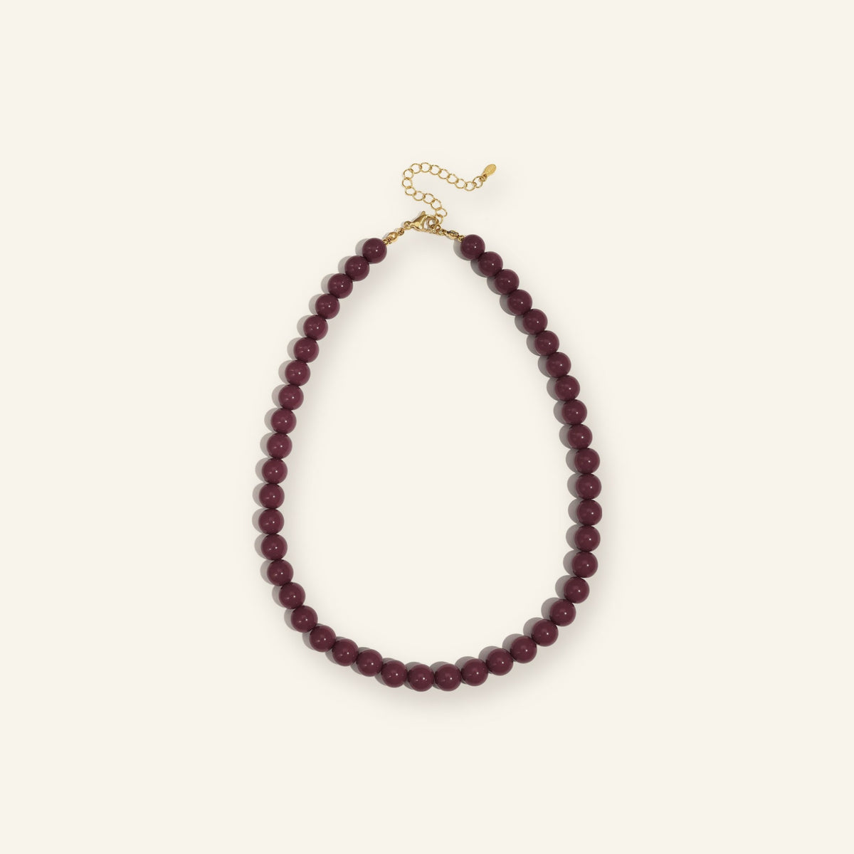 Kralenketting 10 mm bordeaux – vrijstaand op beige