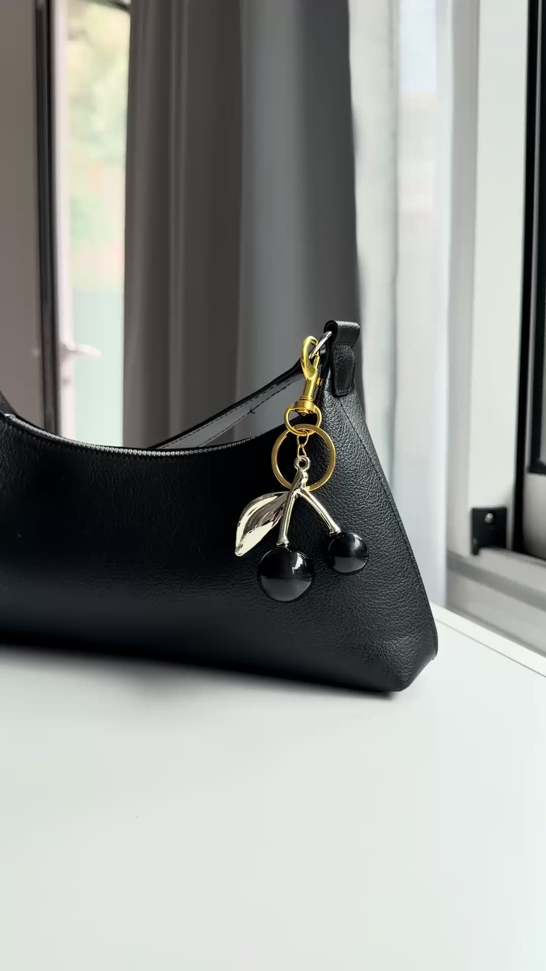 Kersen bag charm zwart aan een tas